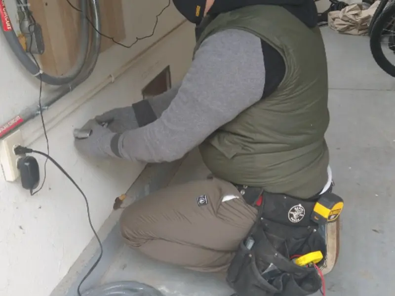 Electrician performing outlet wiring in a Williston Park garage